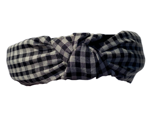 close up shot of a black and white checkered hard headband with a twist top