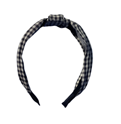 close up shot of a black and white checkered hard headband with a twist top