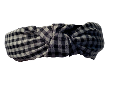  close up shot of a black and white checkered hard headband with a twist top